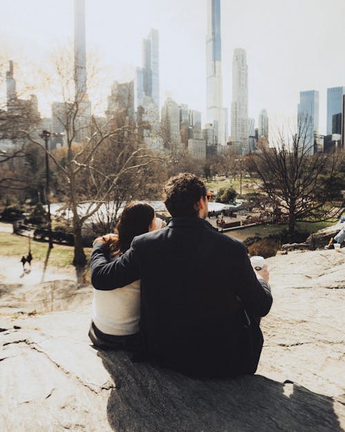 A couple sitting on a rock in central park