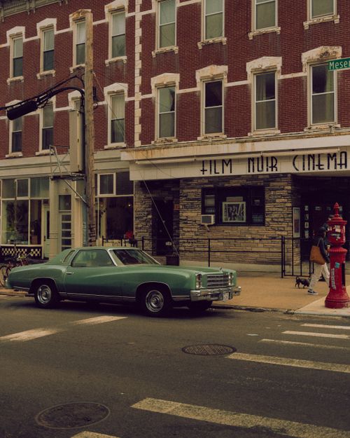 Free Classic Chevrolet Monte Carlo parked by a cinema, evoking urban nostalgia. Stock Photo