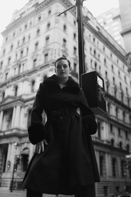 A woman in a black coat standing on a street