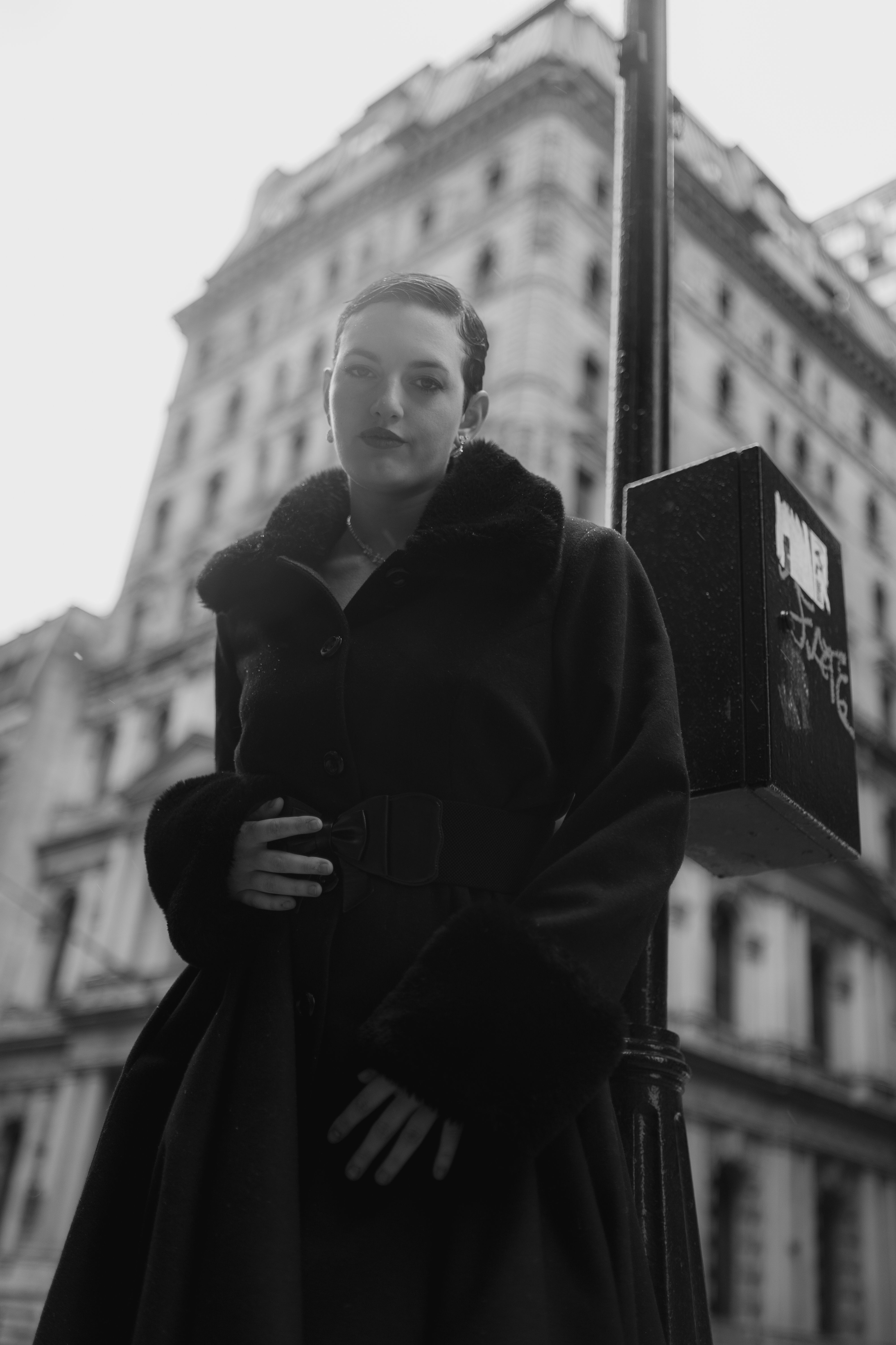 A woman in a coat standing on a street corner · Free Stock Photo