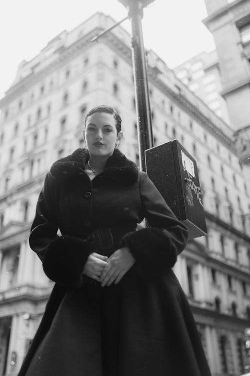 A woman in a fur coat standing on a street