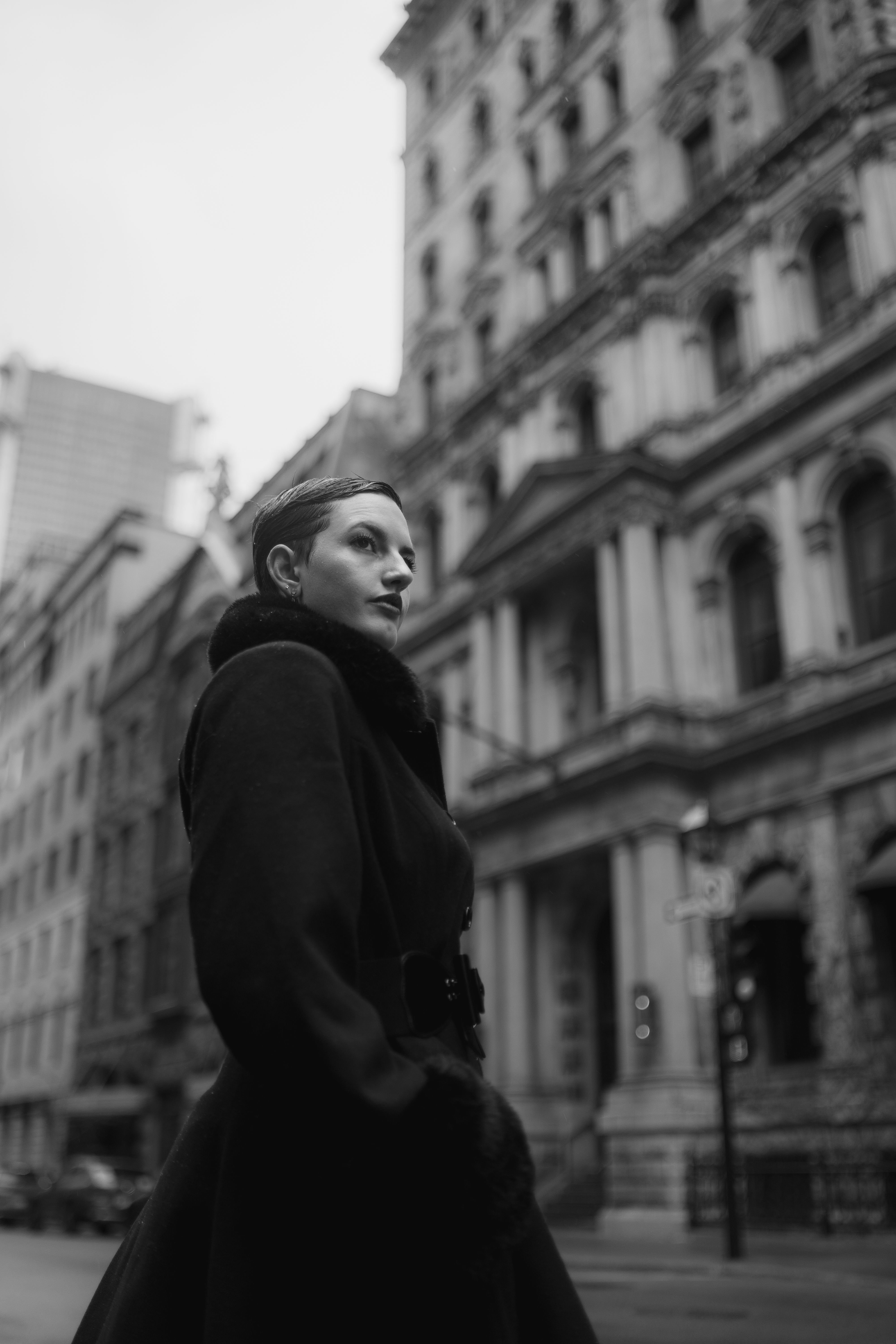 A woman in a black coat is standing on a street · Free Stock Photo