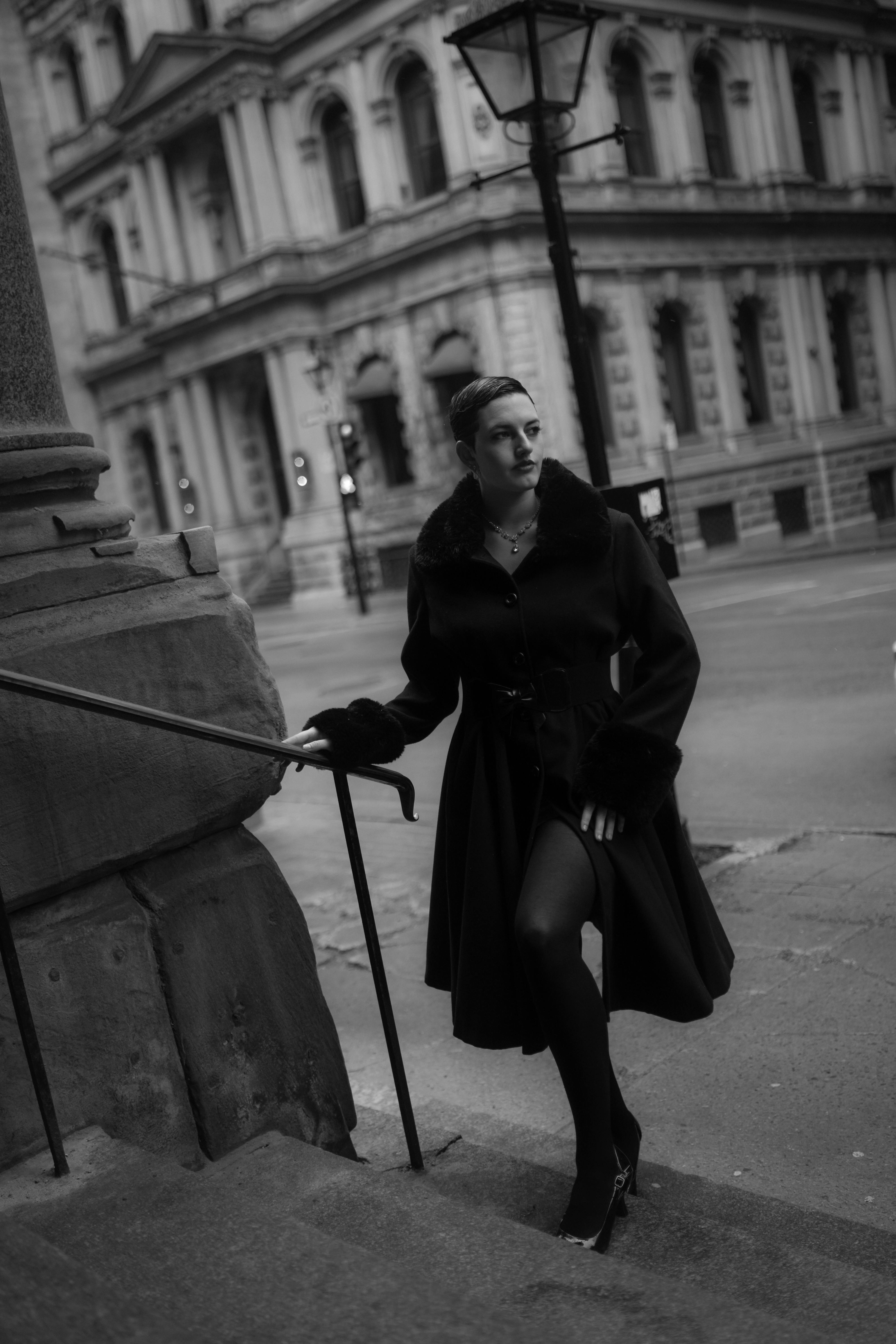 a woman in black and white standing on the steps