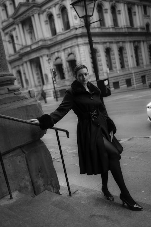 A woman in black and white standing on the steps