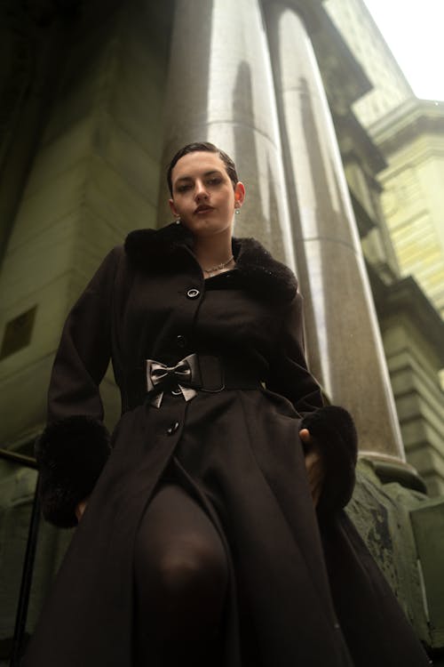 A woman in a black coat and black stockings