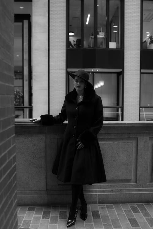 Black and white photo of woman in coat and hat