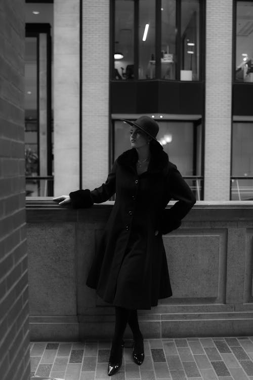 A woman in a coat standing on a ledge