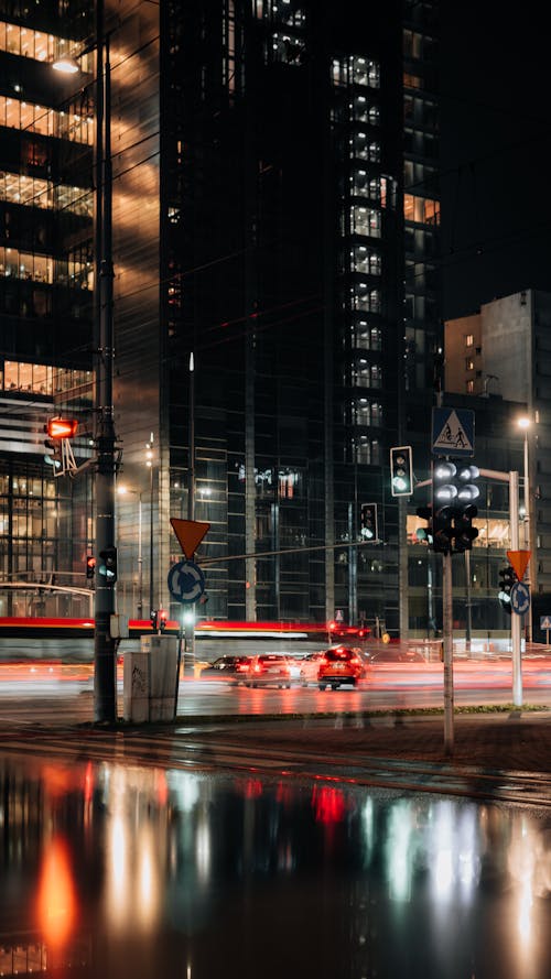 A city street at night with cars and buildings