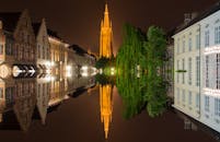 布鲁日历史悠久的建筑在夜间水面灯光的映照下，展现出令人惊叹的景色