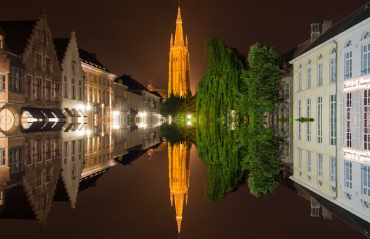 布鲁日历史悠久的建筑在夜间水面灯光的映照下，展现出令人惊叹的景色