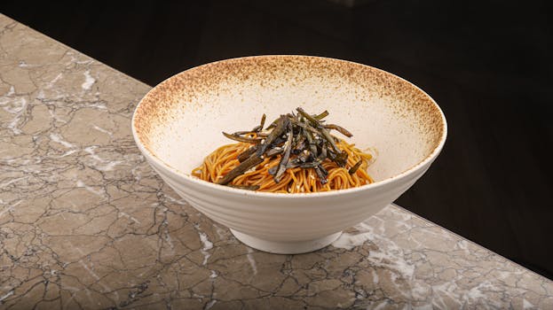 A savory bowl of stir-fried Asian noodles garnished, perfect for a flavorful meal.