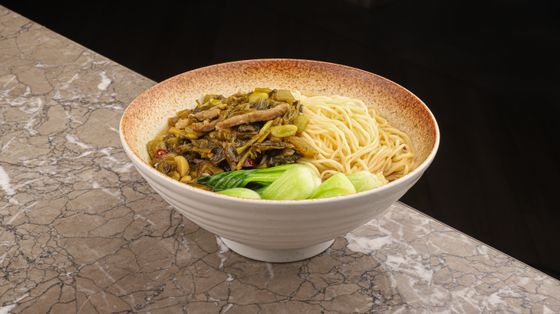 Wheat noodles topped with stir-fried pickled mustard greens, pork strips and baby bok choy