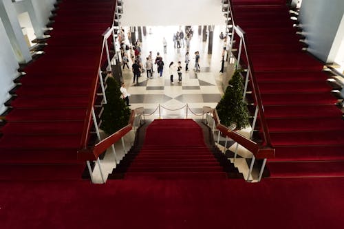 A red carpeted staircase with people walking up it