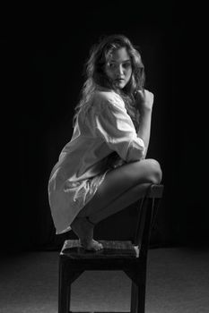 Dramatic black and white portrait of a woman modeling in a studio setting.