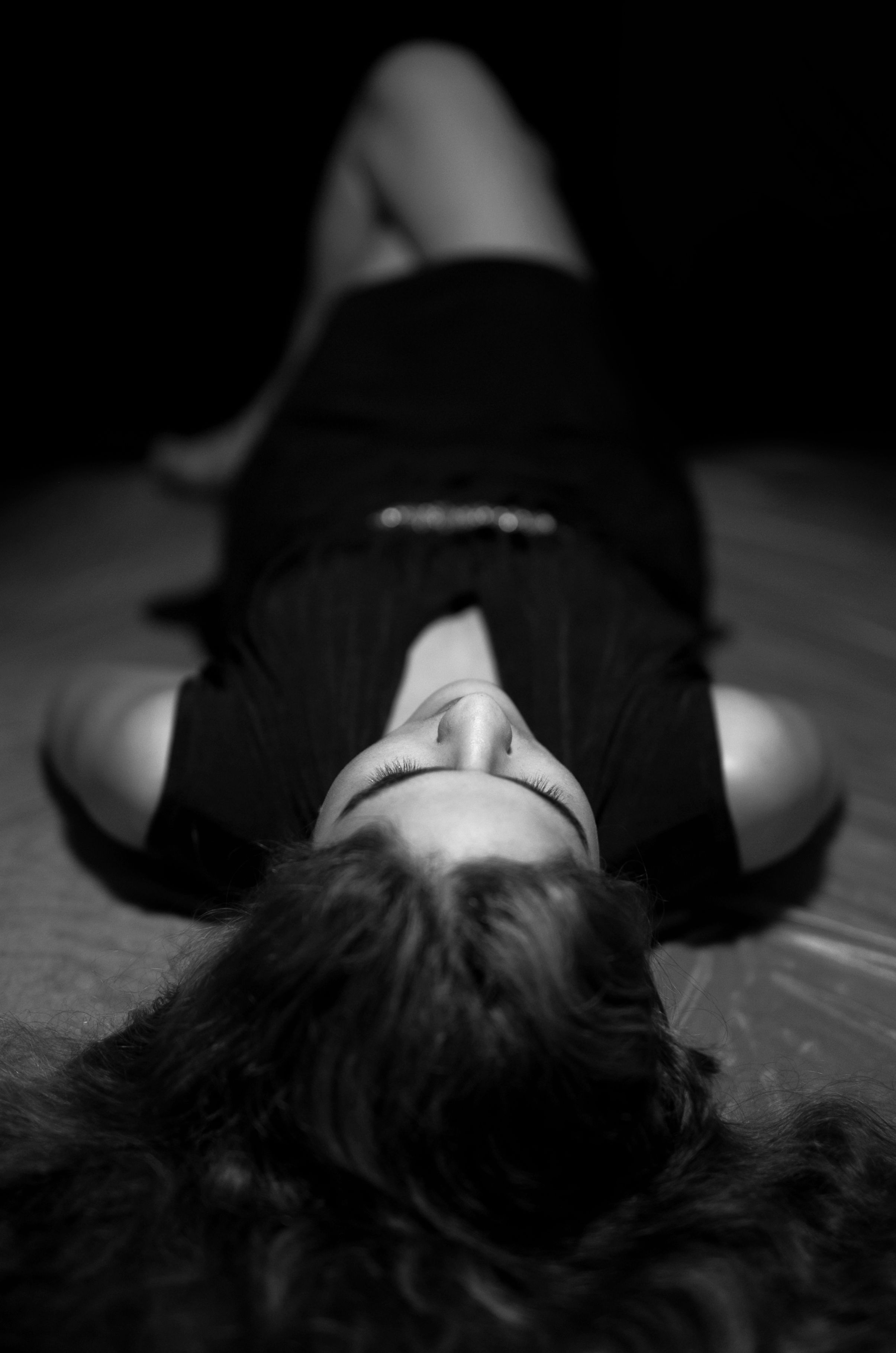 Fotomural Retrato artístico en blanco y negro de una mujer acostada, tomado desde arriba.