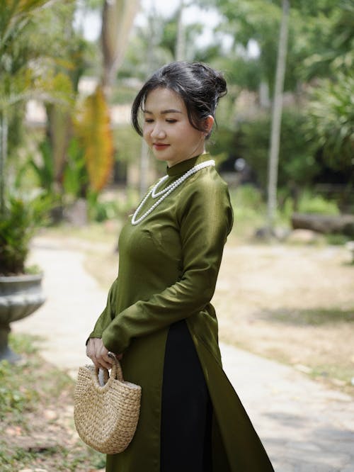 A woman in a green dress and black purse