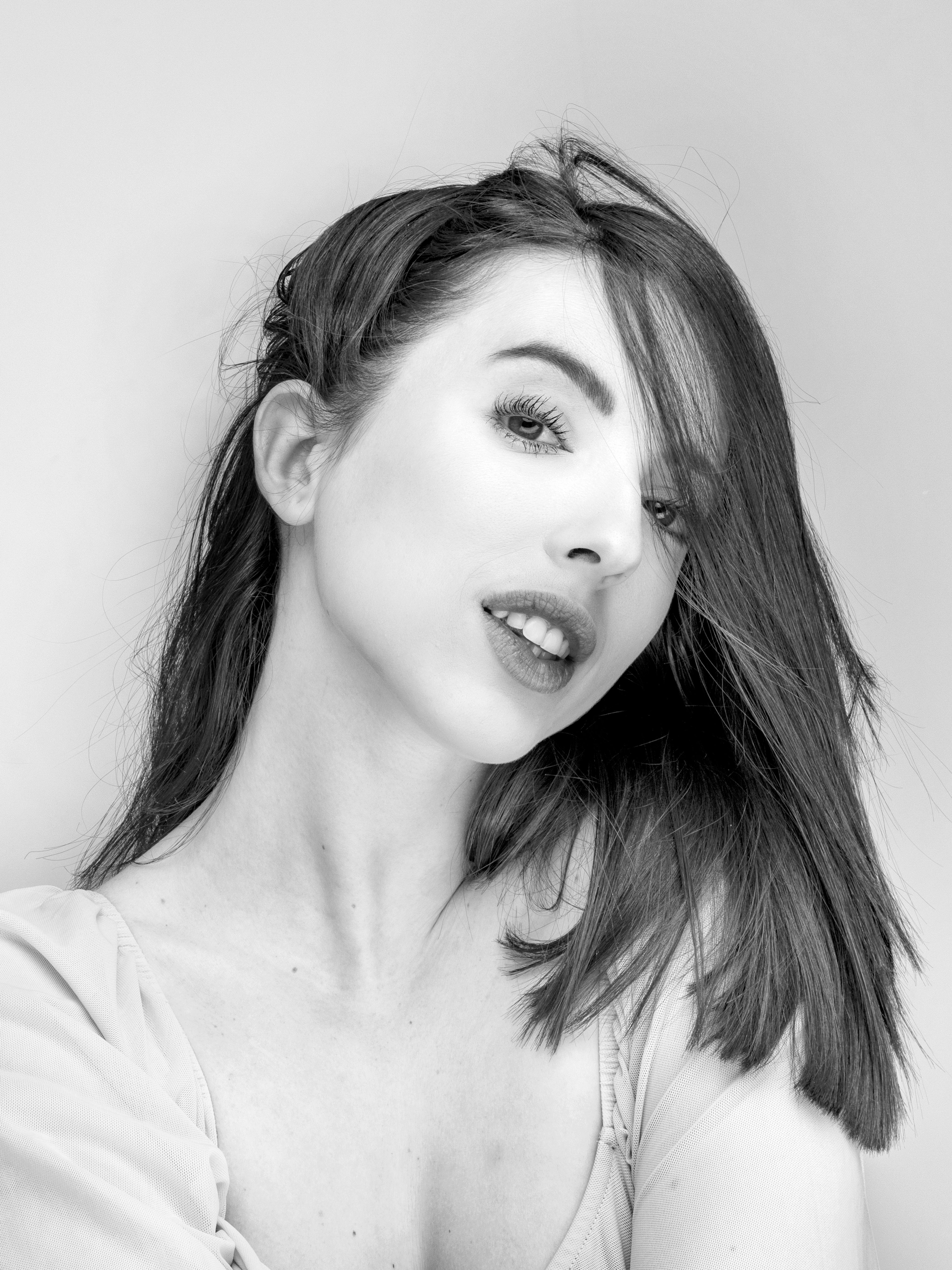 Sophisticated black and white portrait of a young woman with tousled hair in Barcelona.