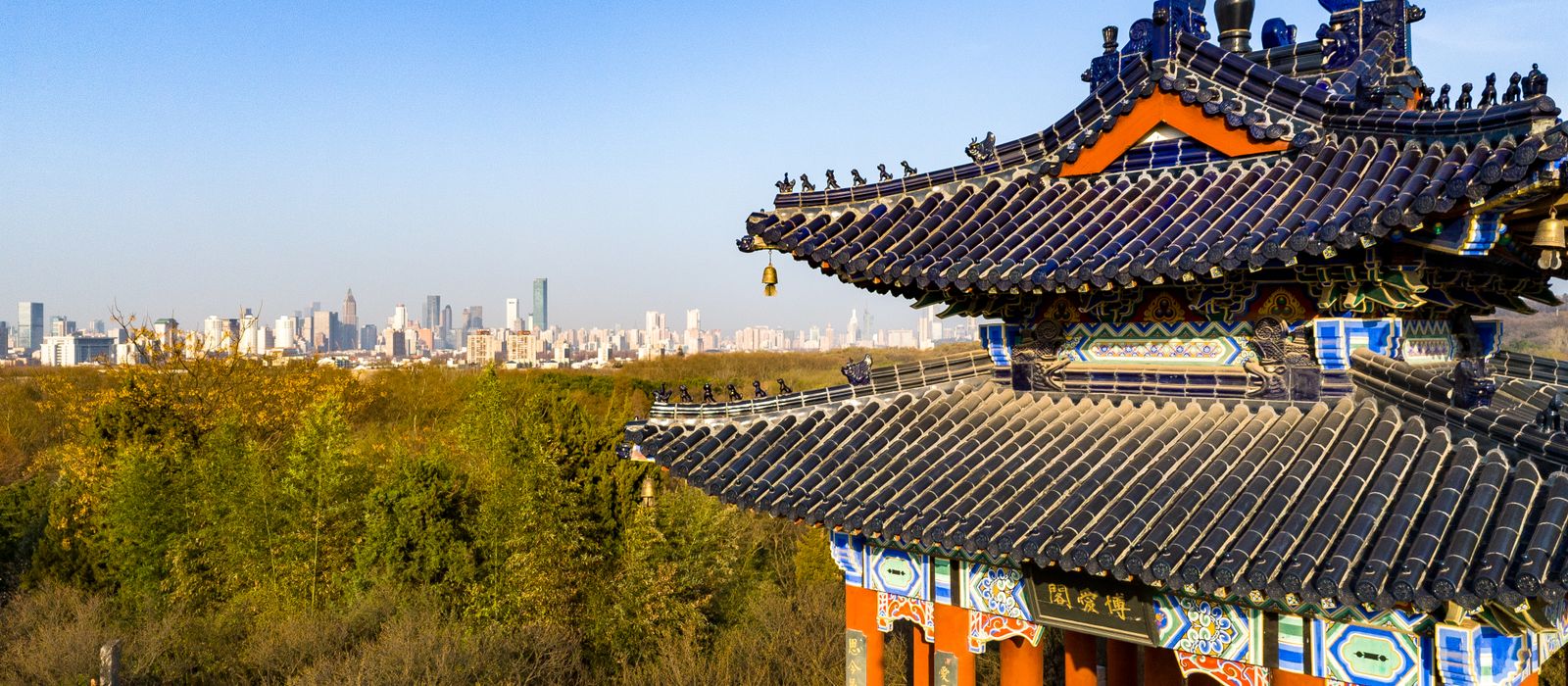 Scenic view of a traditional Chinese pavilion with the Nanjing city skyline in the background. — flights from Hong Kong to Nanjing