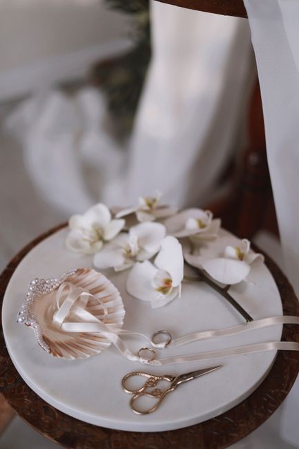 Close-up of wedding accessories with orchids and elegant decor on a plate.
