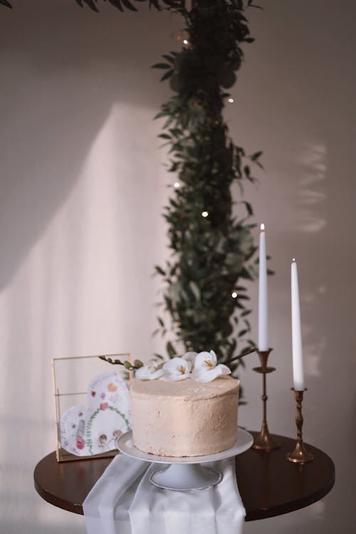 A cake on a table with candles and greenery