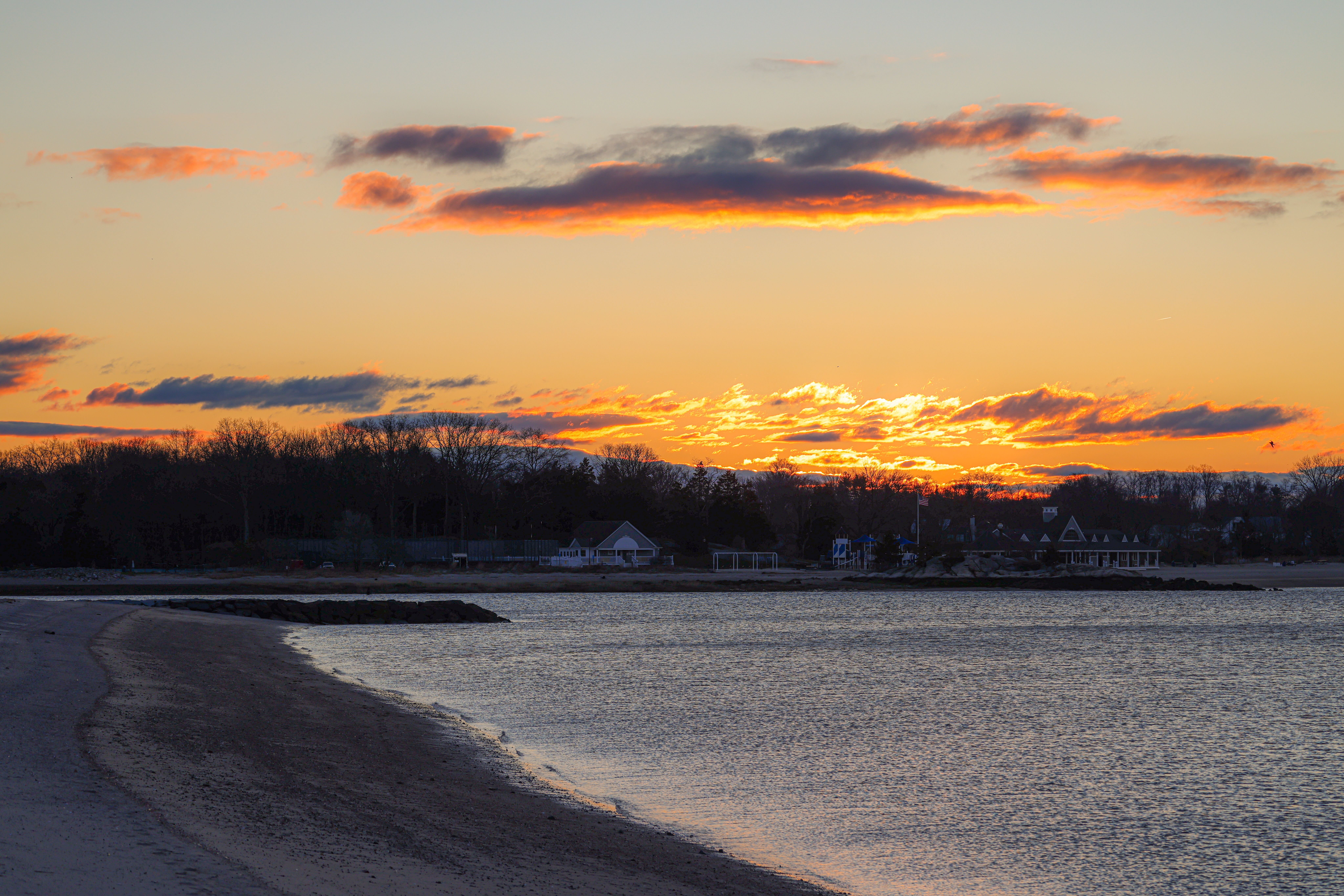 Capture of a vibrant sunset over the coastline and beach houses in Stamford, CT.