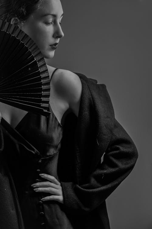 Black and white photo of woman holding fan