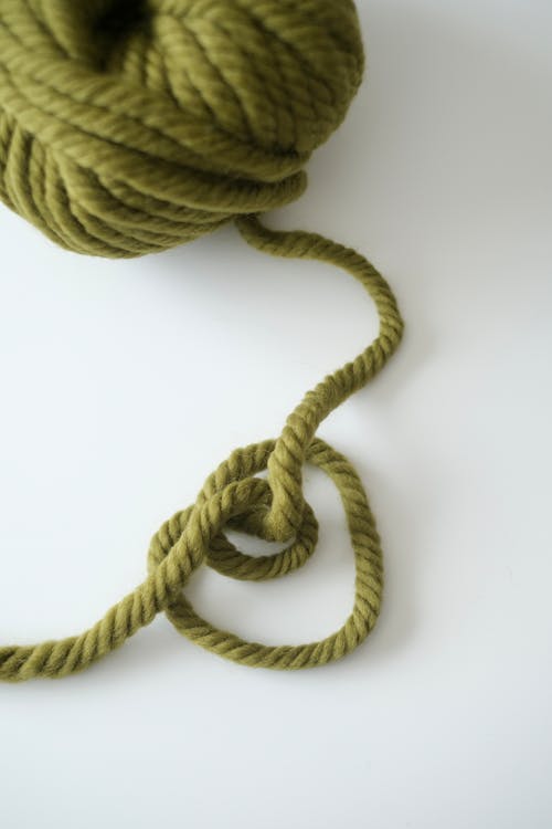 A green yarn ball with a knot on it