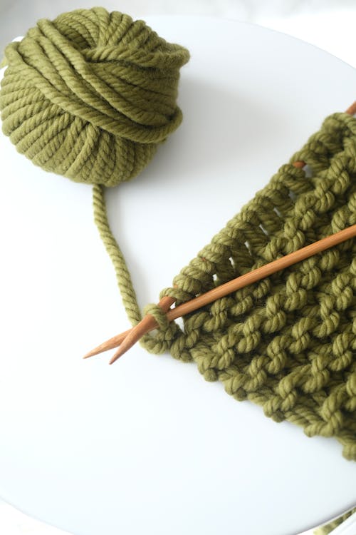 A knitting needle and yarn are on a table