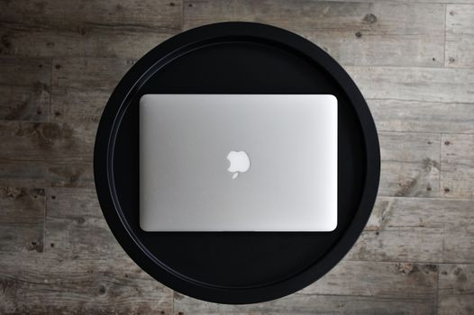 Top view of a closed laptop on a black table, perfect for tech or work concepts.