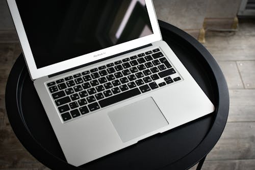 A laptop computer sitting on top of a black table