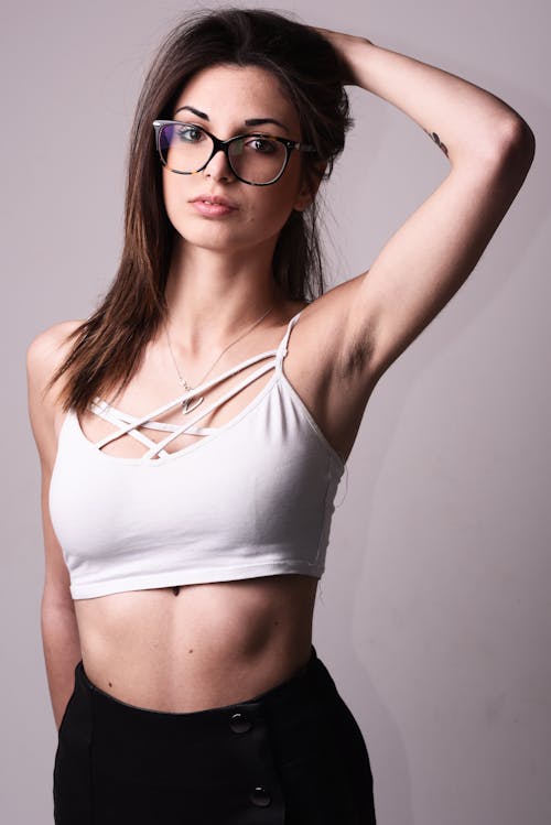 A woman in glasses and a white crop top
