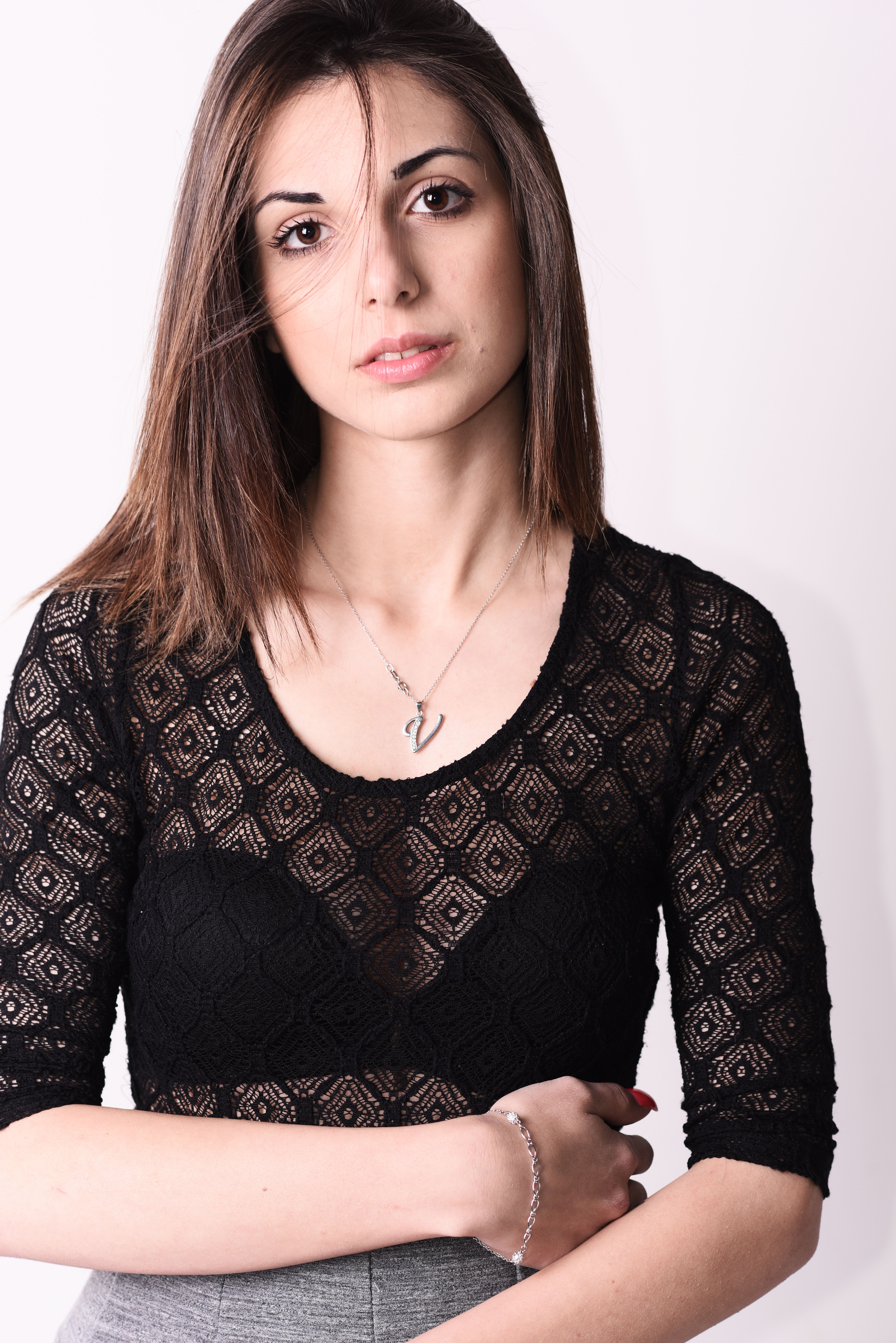 A stylish portrait of a young woman wearing a black lace top, emphasizing beauty and elegance.