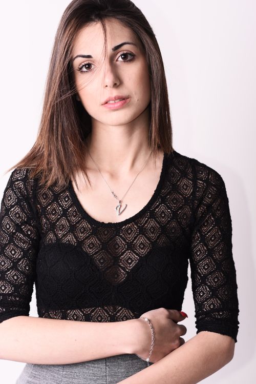 Free A stylish portrait of a young woman wearing a black lace top, emphasizing beauty and elegance. Stock Photo