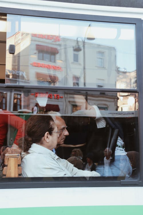 A man and woman sitting in a bus looking out the window