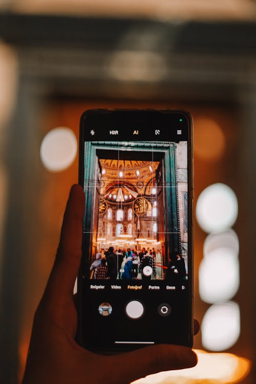 A person holding up a cell phone with a photo of a church