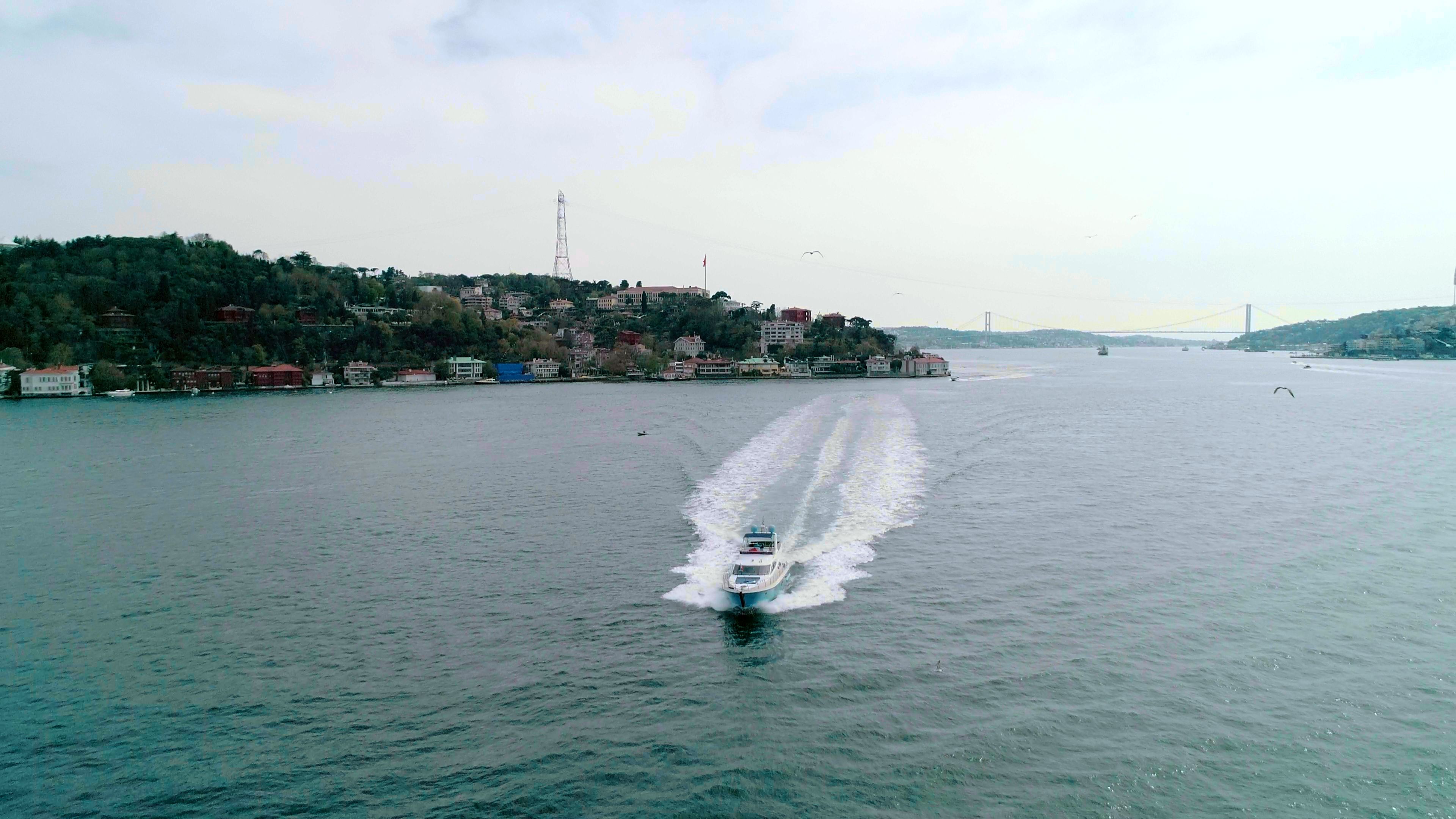 Motorboat cruising the Bosphorus with a view of İstanbul's cityscape and bridge.