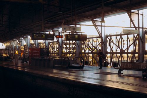 Free Commuters at a modern train station under warm indoor lighting. Stock Photo