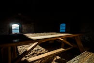 在一个黑暗的石头房间里，阳光透过窗户照射在木制野餐桌上