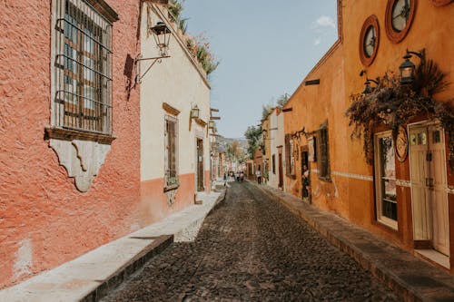 A narrow street with colorful buildings and a cobblestone path