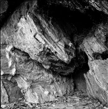 A black and white photo capturing eroded rock formations in a cave setting.