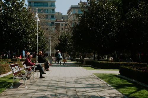 Free A bustling park in Istanbul with people enjoying a sunny day among greenery and urban architecture. Stock Photo