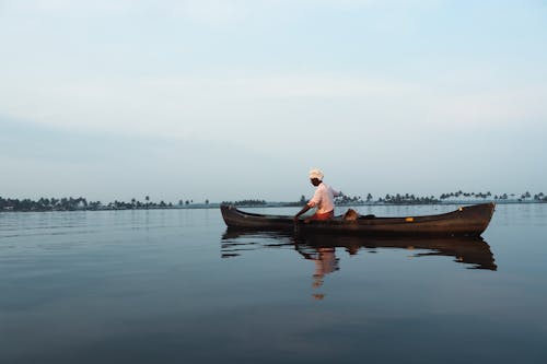 View of a Man in a Boat on a Lake 