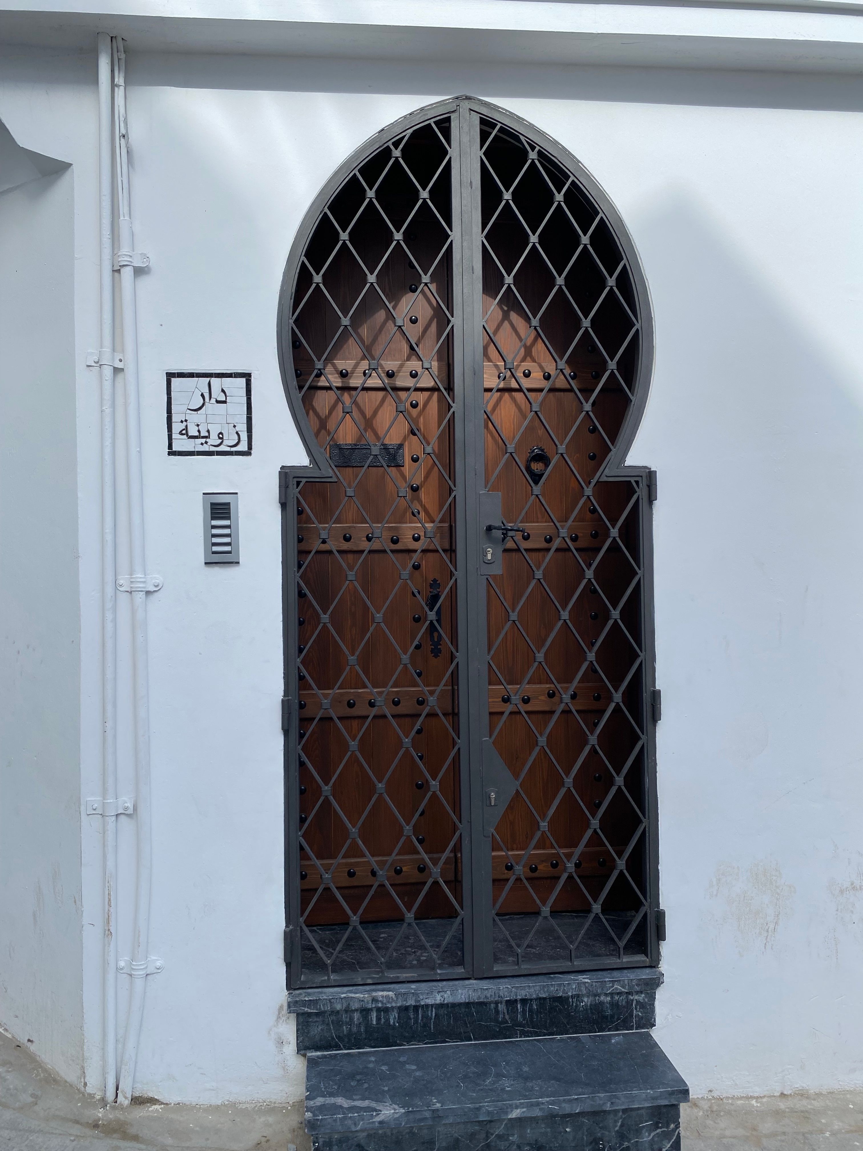Elegant wooden door with gothic ironwork, showing traditional architecture.