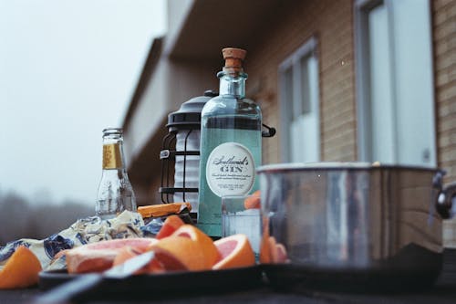 Free A table with a bottle of gin, oranges and a knife Stock Photo