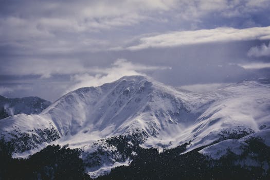 Breathtaking view of a snow-capped mountain under a cloudy sky in winter.