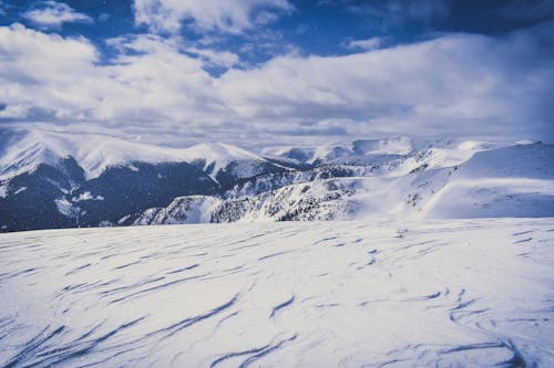 Gunung Yang Tertutup Salju Di Bawah Langit Biru Dan Awan Putih