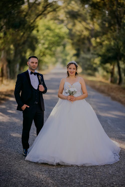 A bride and groom standing on a road