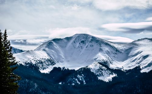 Free Snowy mountain peaks under a cloudy sky, showcasing nature's winter beauty. Stock Photo