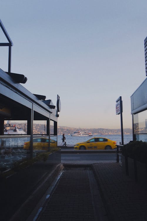 A yellow taxi is parked in front of a restaurant