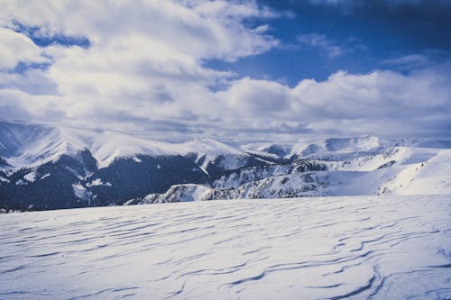 Free Snow Covered Hills Under White Clouds Stock Photo